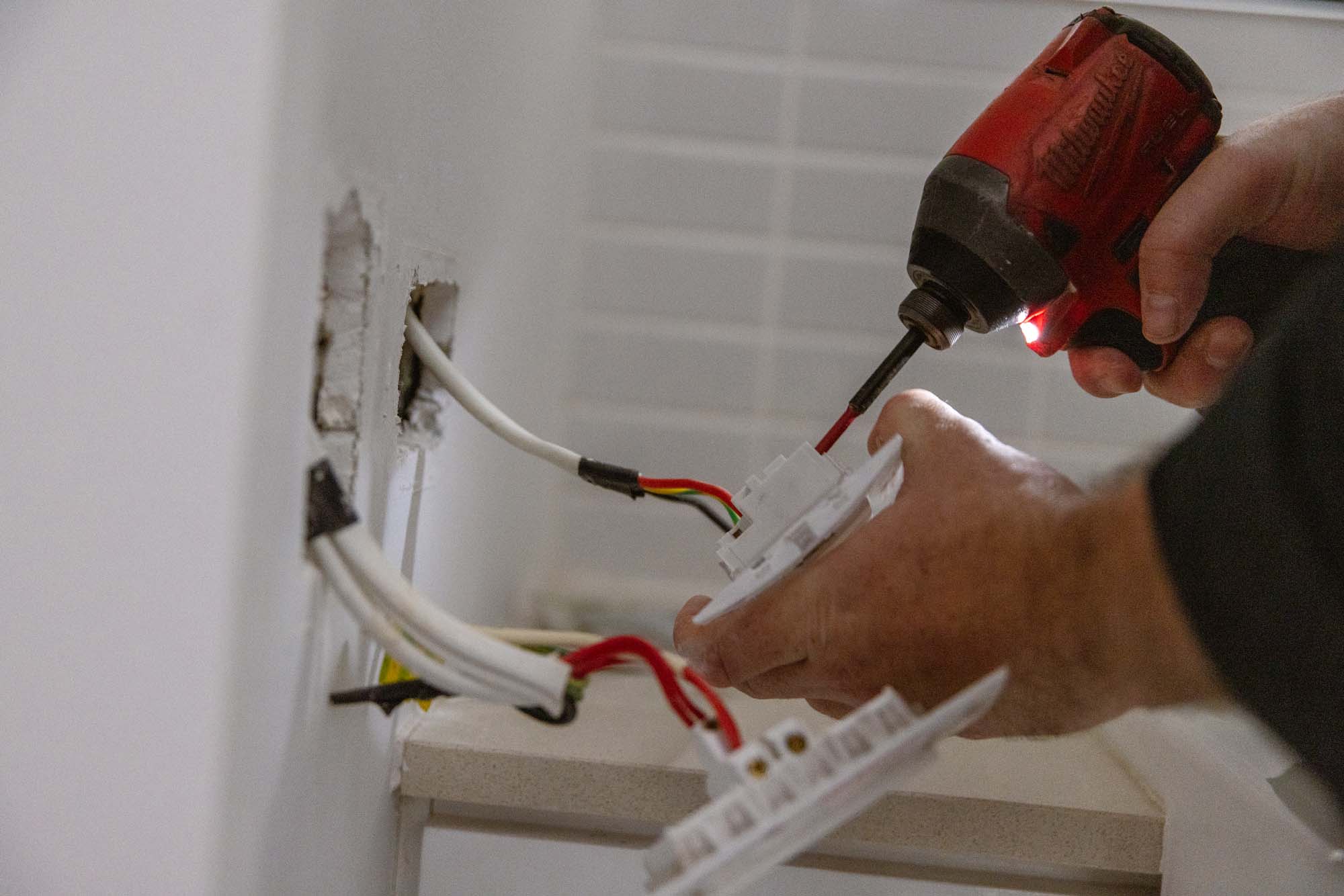 An electrician wiring a power point